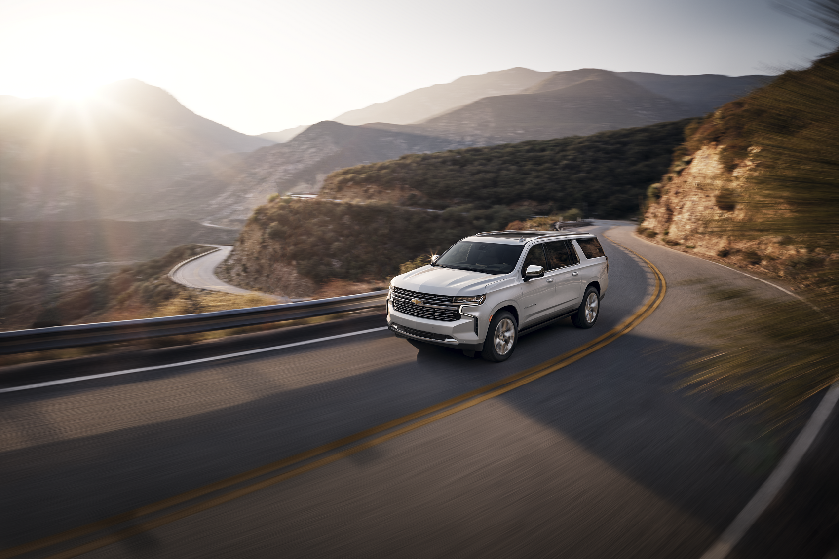white chevy SUV drives past mountain overlook